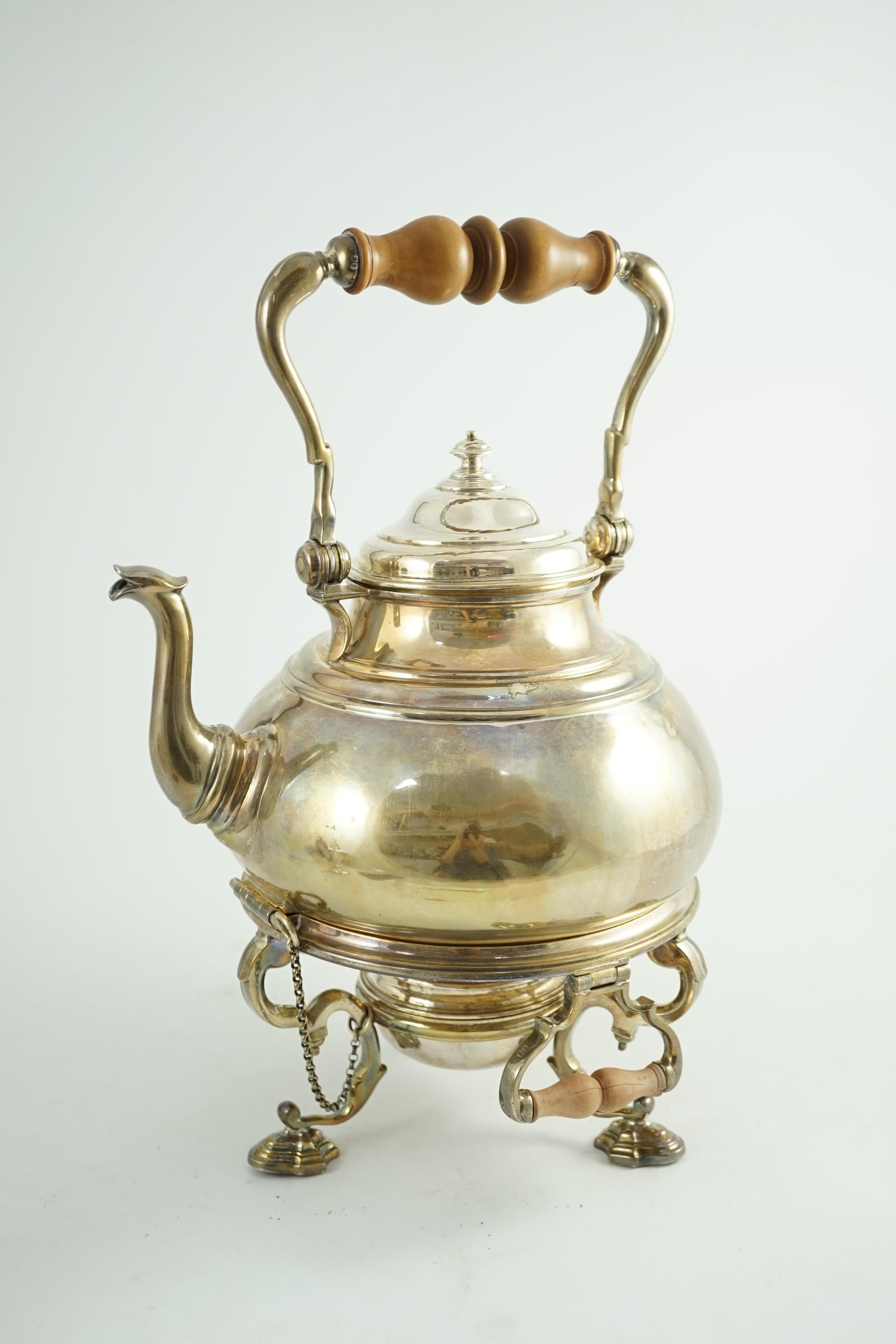 A large George V Britannia standard silver tea kettle on two handled stand, with burner, by Charles & Richard Comyns